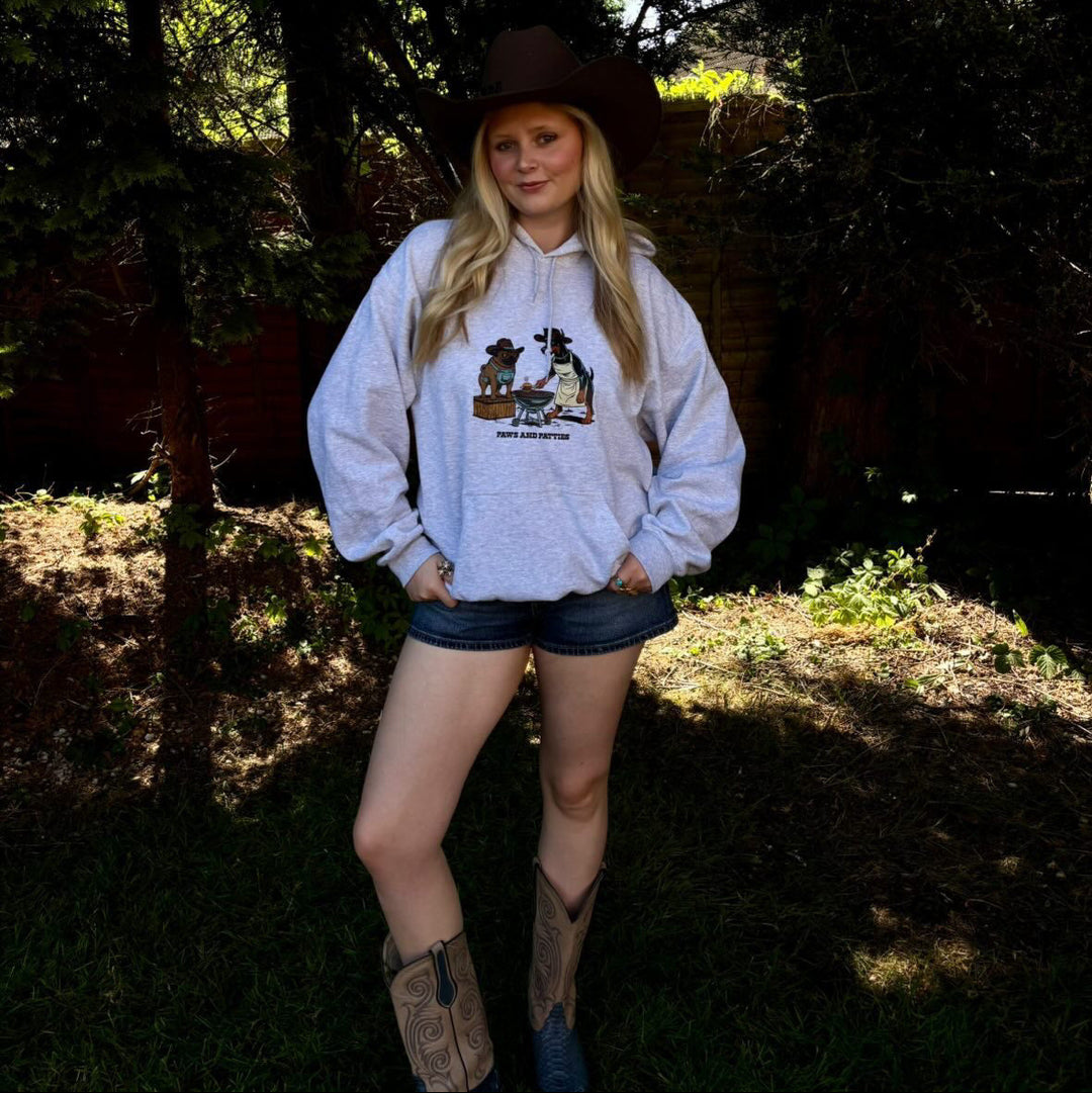 Person wearing a white sweatshirt with a graphic design outdoors.