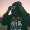 Person wearing a dark hoodie with 'Midnight Bandit' graphic design outdoors.